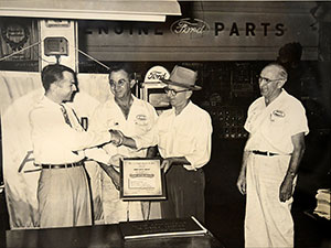 James W. Sneed, in hat, in front of the parts department at Sunrise Ford at its first formal location
